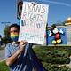 Disney employee Nicholas Maldonado holds a sign that reads "Trans Rights Are Human Rights" while protesting outside of Walt Disney World